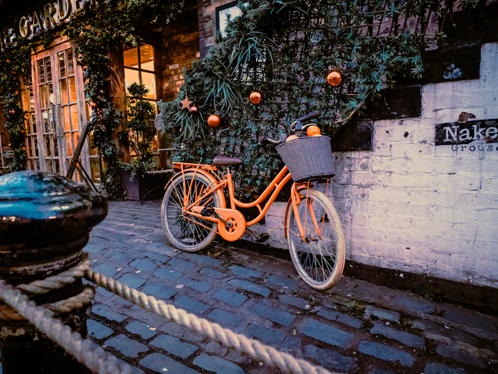 Orange city bicycle parked beside a historic building