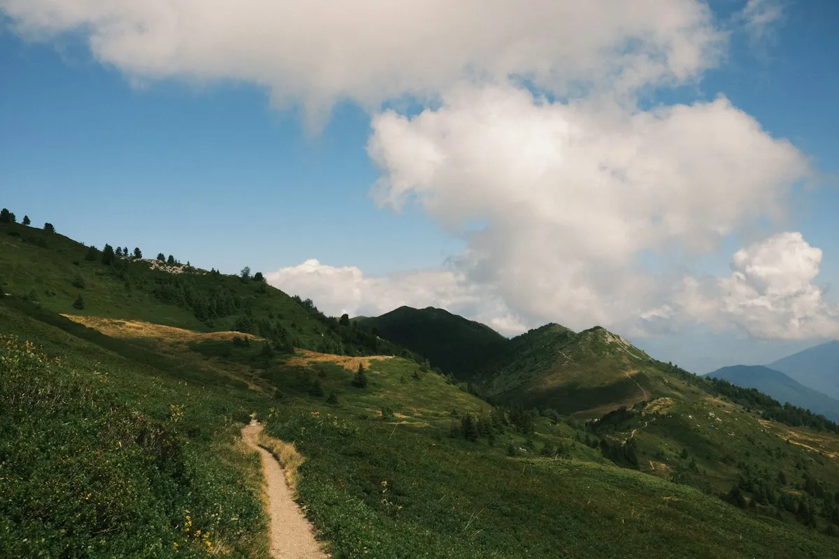 Green mountain path under a blue sky